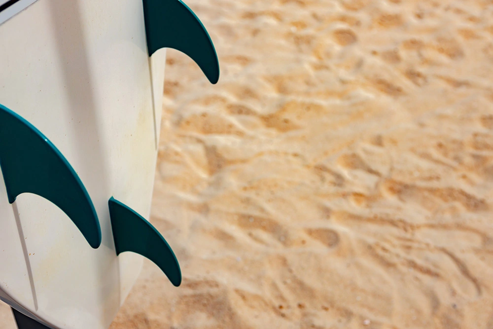 tails-of-gun-surfboard-on-the-sand